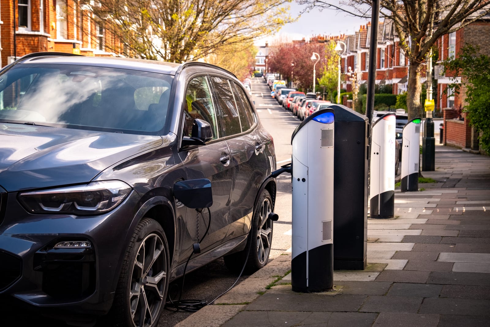 Electric vehicles charging at curbside stations on a residential street